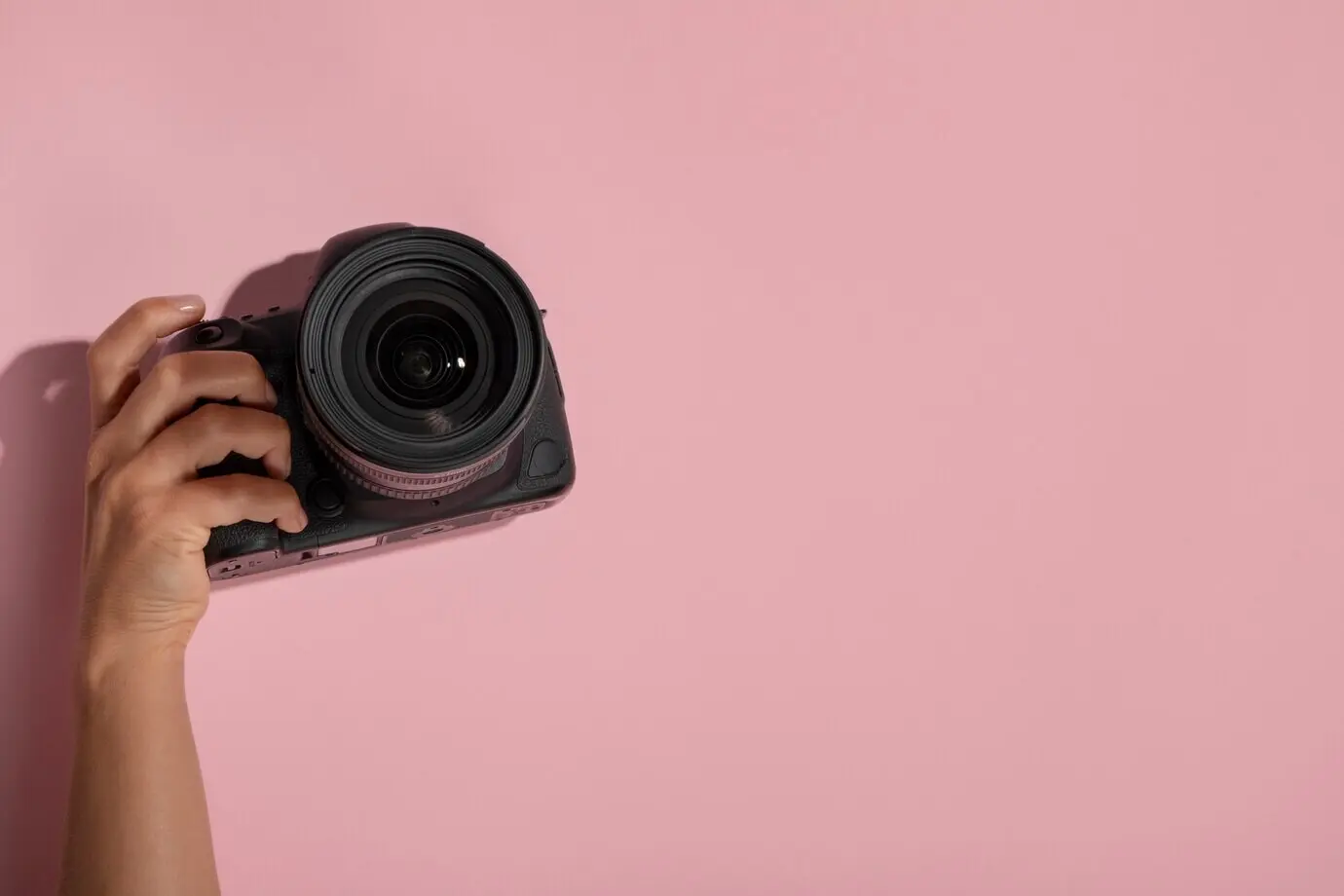 Blick auf eine Person, die eine professionelle Digitalkamera hält.