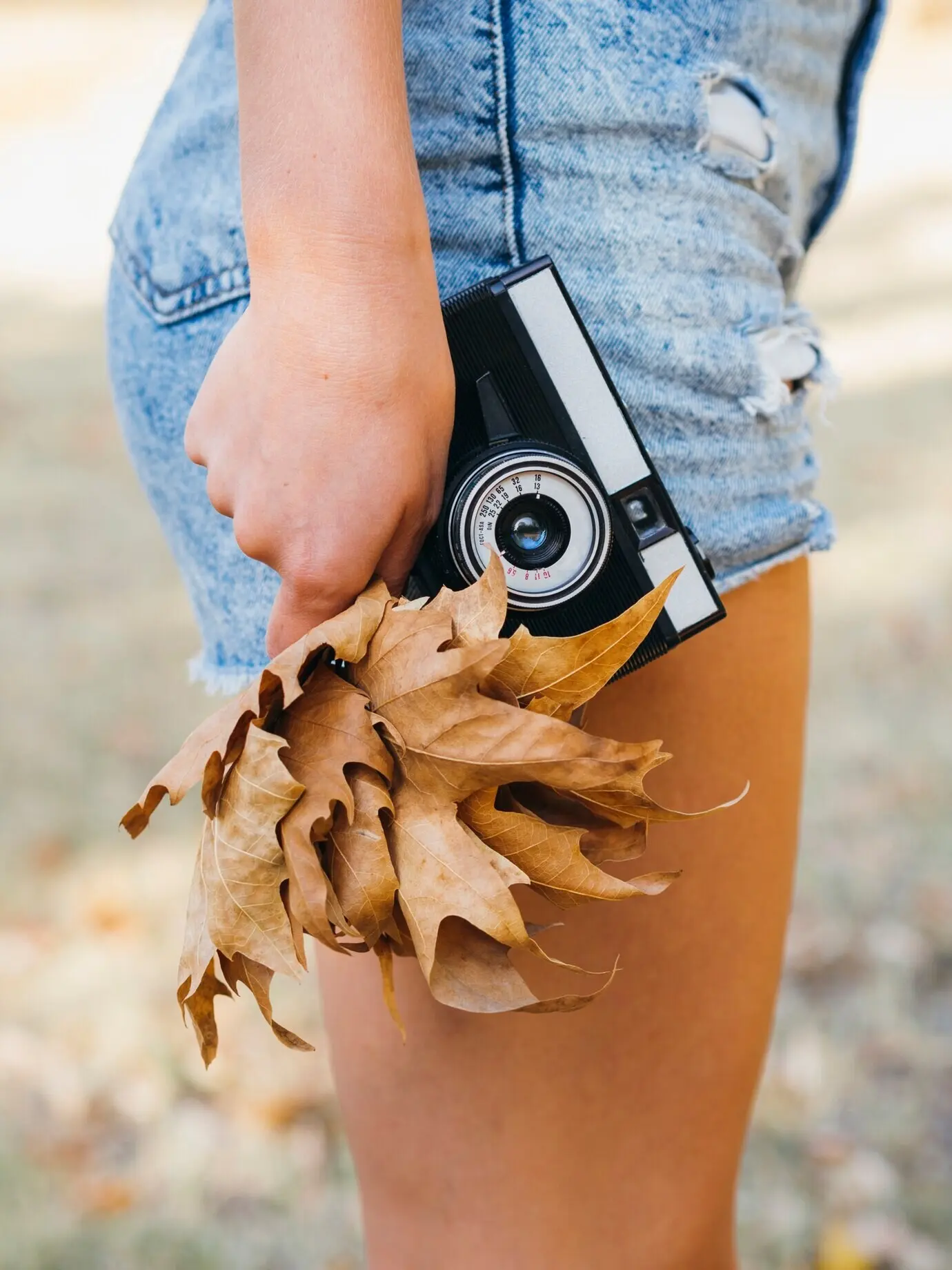 Nahaufnahme einer von einer Frau gehaltenen Fotokamera.